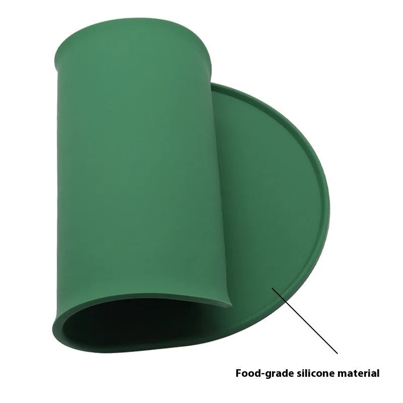 Green silicone waterproof placemat for cat bowls on a wooden floor