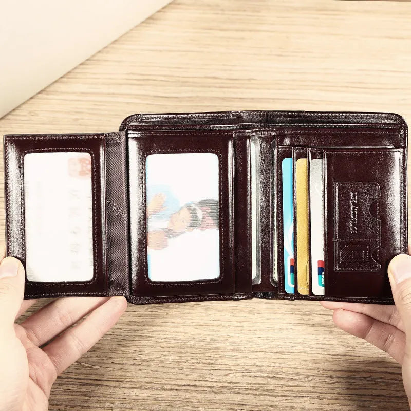 Men's brown leather bifold wallet open to show internal card slots, coin pocket, and photo holder.