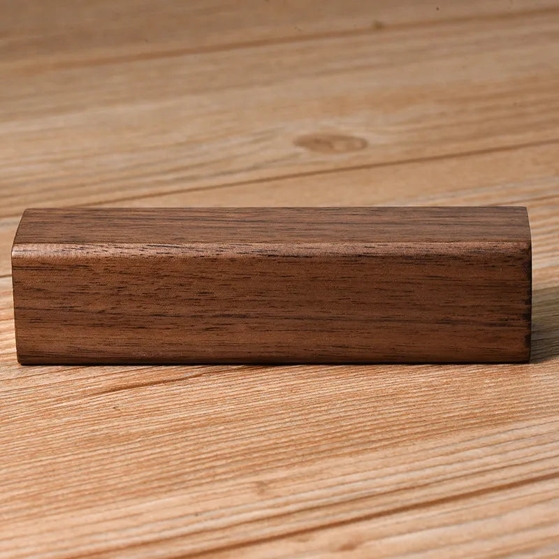 Brown walnut wood portable power bank with dimensions 100mm by 25mm.