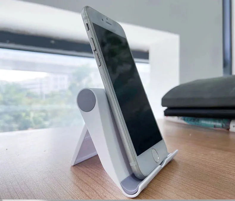 Black PE folding mobile phone stand with soft rubber grip in open position holding a smartphone
