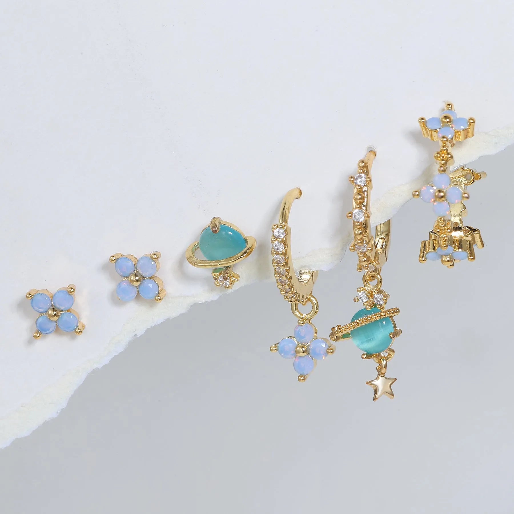 Gold and silver floral stud earrings with blue protein flower nail and zircon mosaic detail.