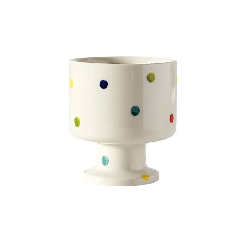 A handmade, irregularly shaped ceramic mug in a solid colour, shown on a table.