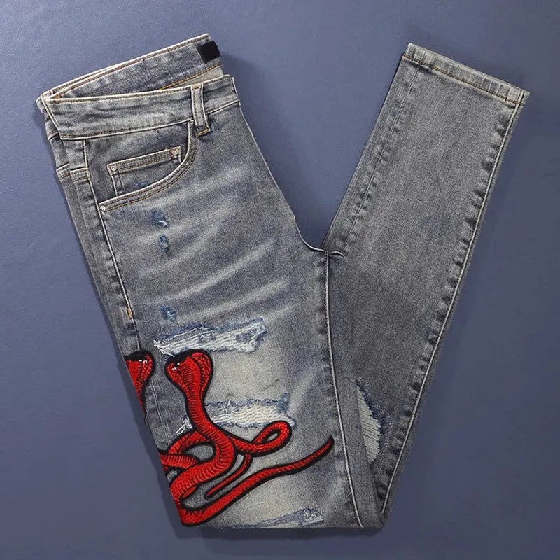 Distressed slim fit jeans with embroidered patches and washed-out vintage colour