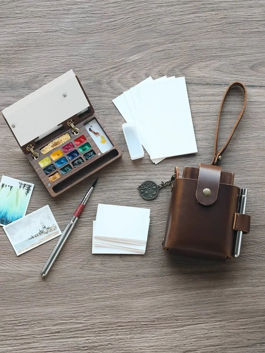 Mini walnut wood watercolour paint box open to show pigment pans inside