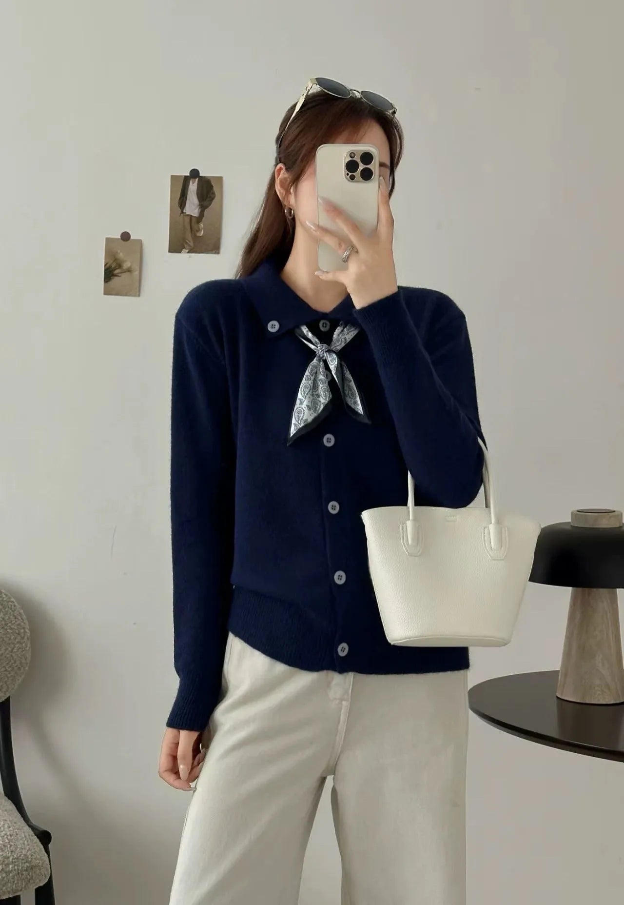 Beige acrylic cardigan with lapel scarf collar and splicing detail on a hanger.