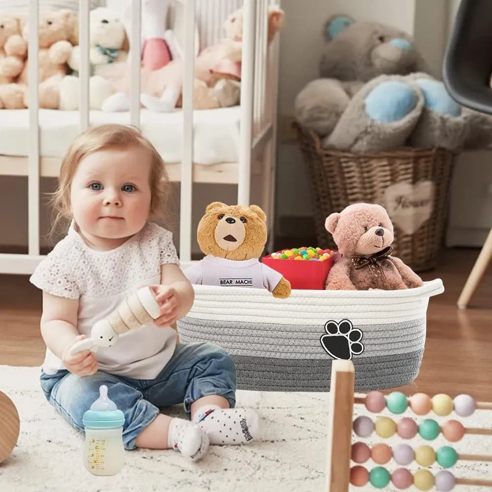 Light beige handmade cotton rope woven storage basket with wooden accents and handles.