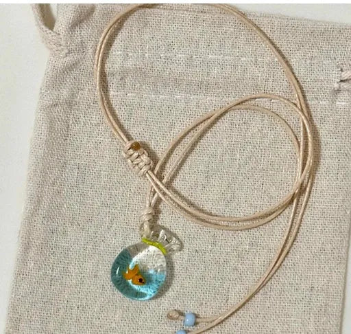 Women's necklace with coloured glaze joker pendant on a woven cotton and linen clavicle chain.