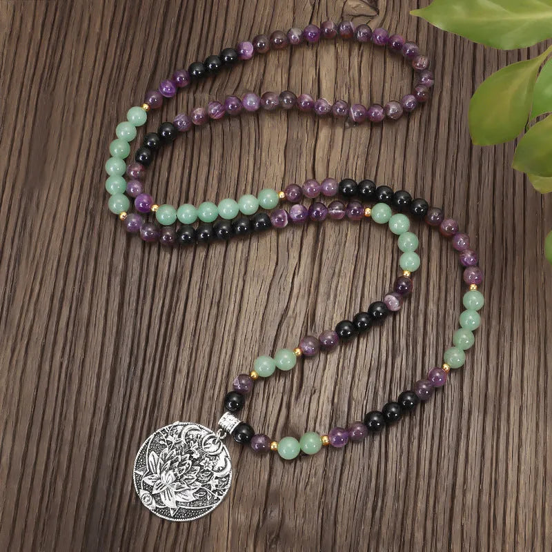 Long yoga necklace with lotus pendant and stone beads alongside matching bracelet