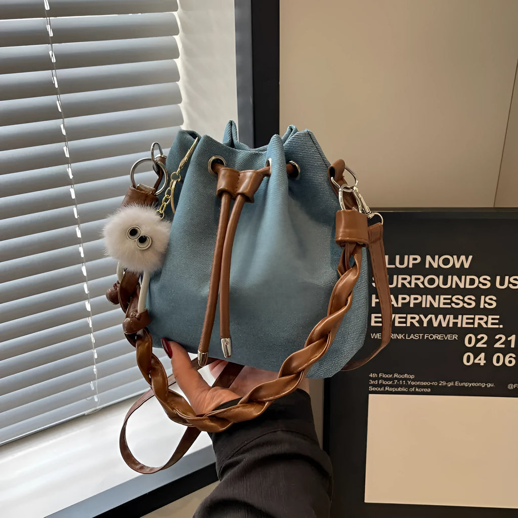 Blue synthetic leather cross body bucket bag with shoulder strap and organised pocket compartments