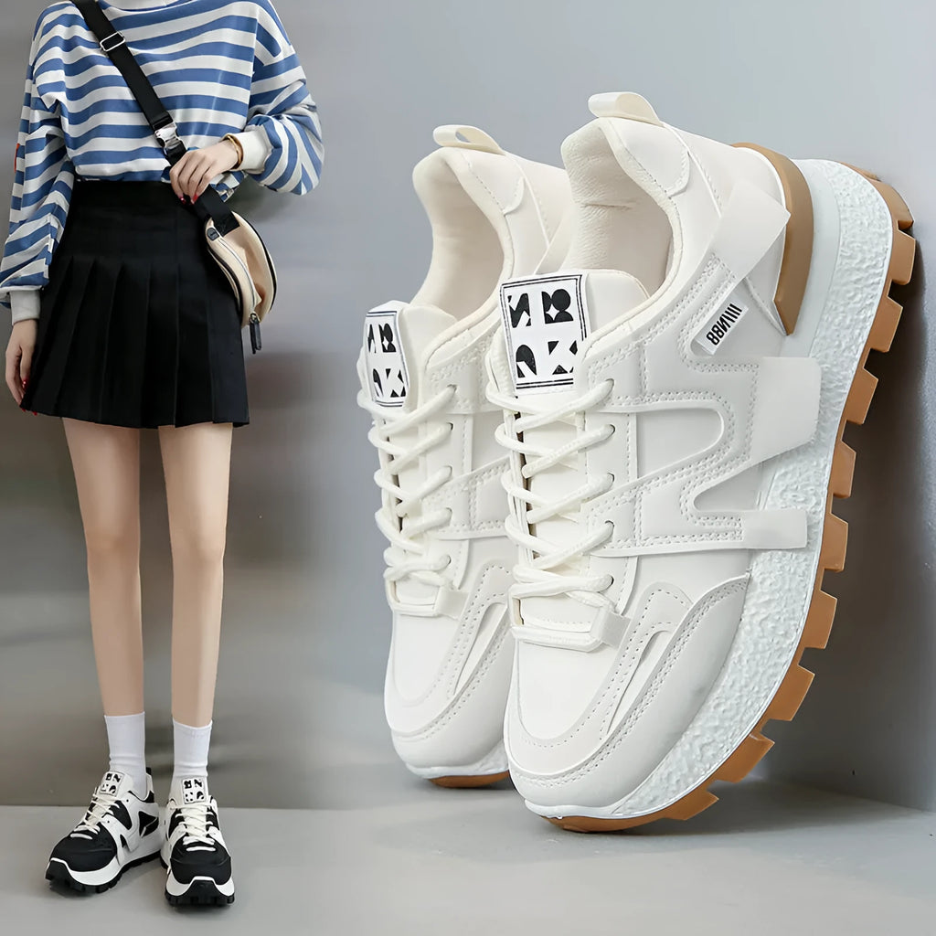 Unisex low-top sneaker in black with round toe, flat heel, and lace-up front on a rubber sole.