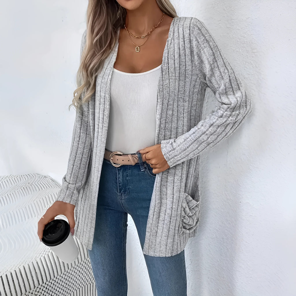 A woman's loose-fit long sleeve cardigan in Grandad Grey with pockets, shown on a hanger.