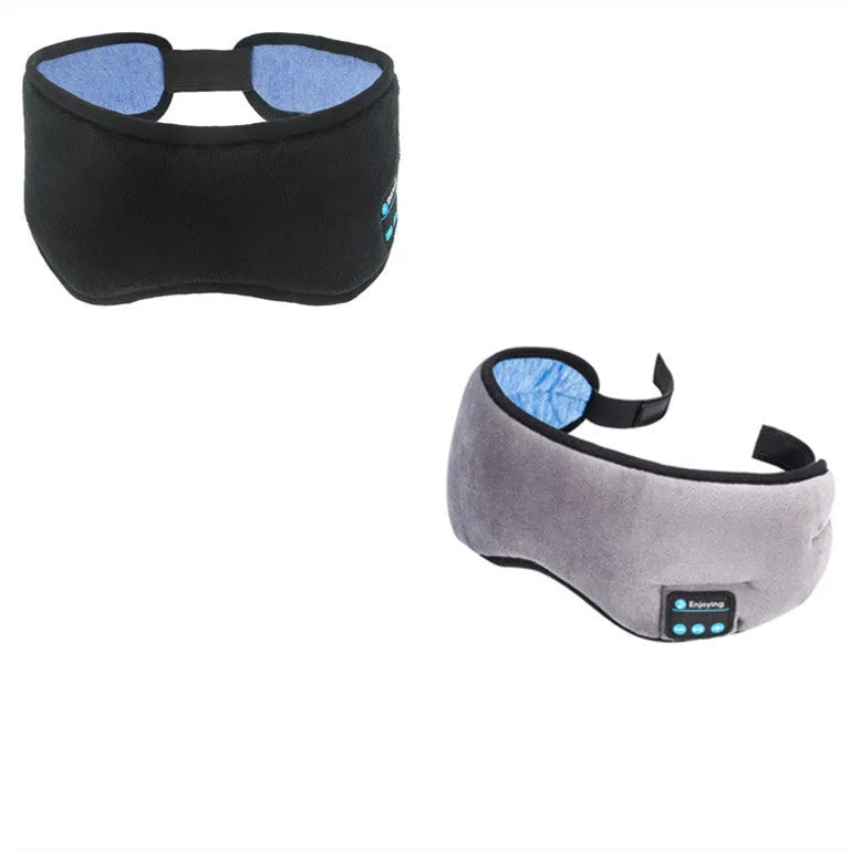 Black Bluetooth sleep eye mask with small integrated wireless earphones, shown in a relaxed position on a pillow.