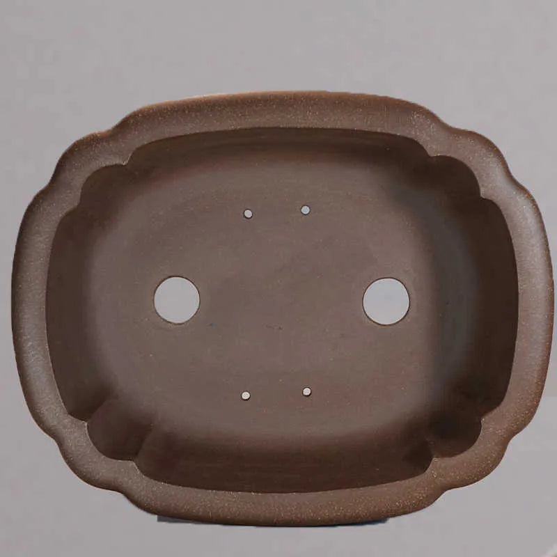 Purple clay handmade rectangular antique flower pot on a desktop.