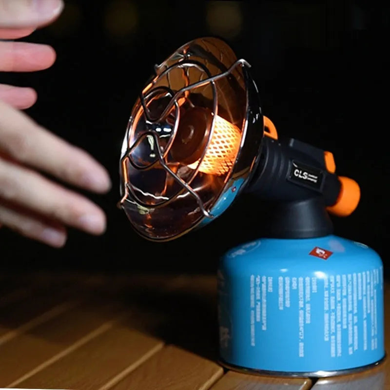 Black and orange mini portable outdoor heating stove with automatic ignition on a table.