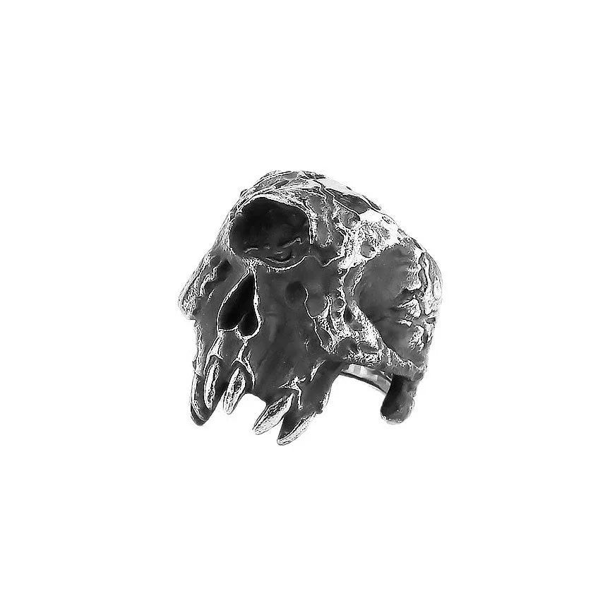 Close-up of a retro alloy ring with a detailed one-eyed skull design on a dark background.