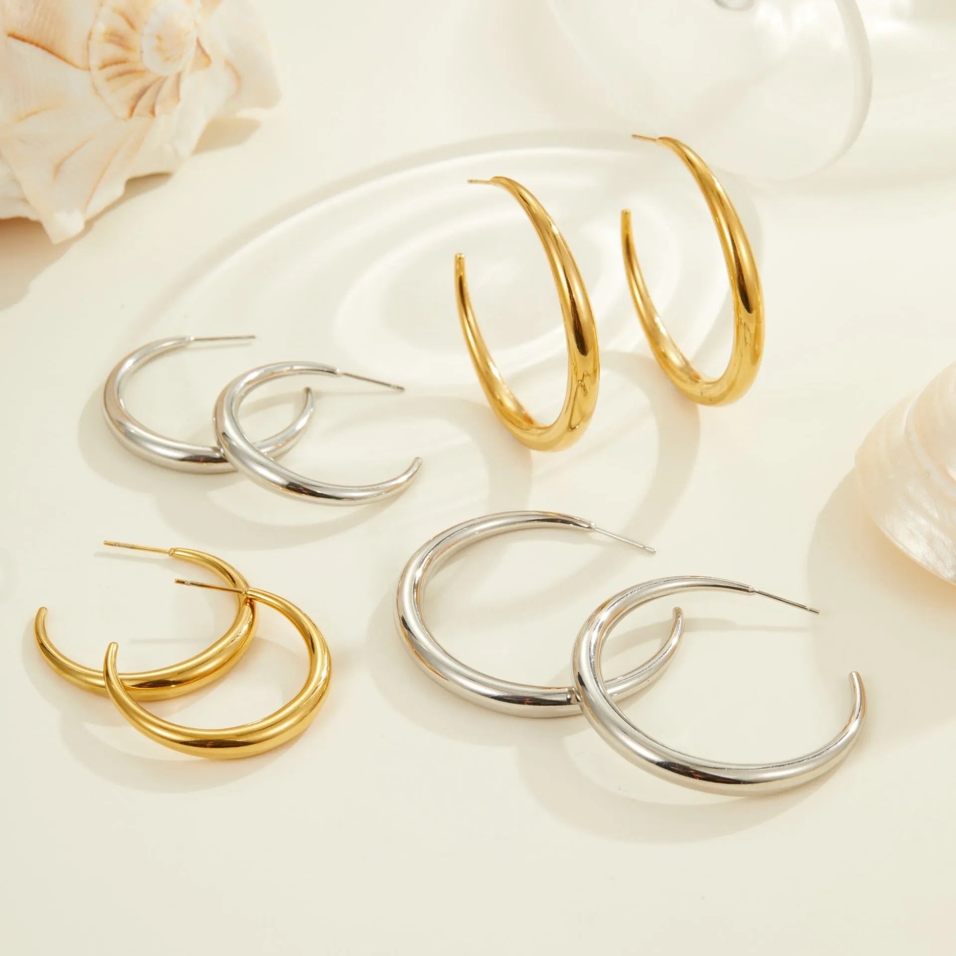 Geometric round hoop earrings in titanium steel with 18K gold plating, available in small and large sizes