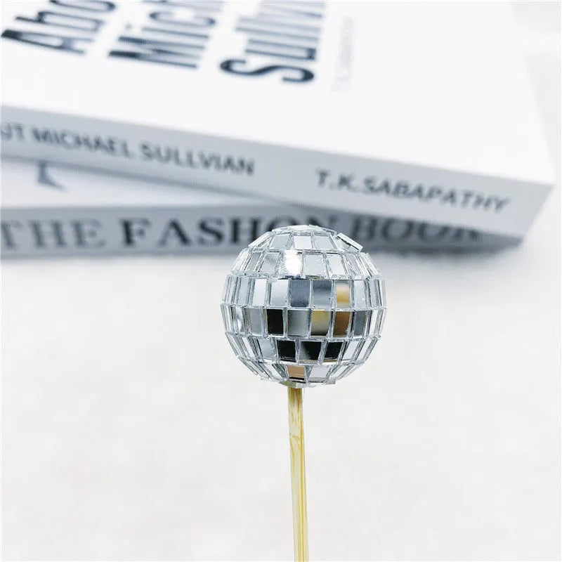 Glass mirror disco ball cake topper on a wooden stick for birthday party cupcakes.