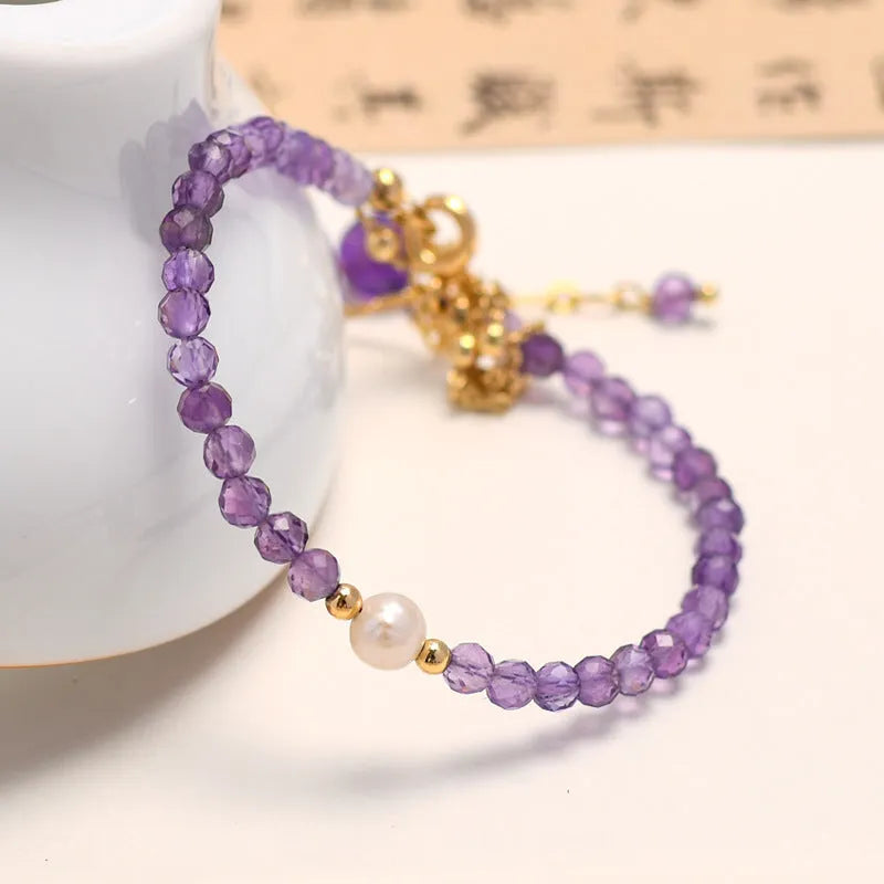 Close-up of a women's amethyst crystal bracelet with a diamond shape and Chinese style design.