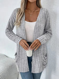 A woman's loose-fit long sleeve cardigan in Grandad Grey with pockets, shown on a hanger.