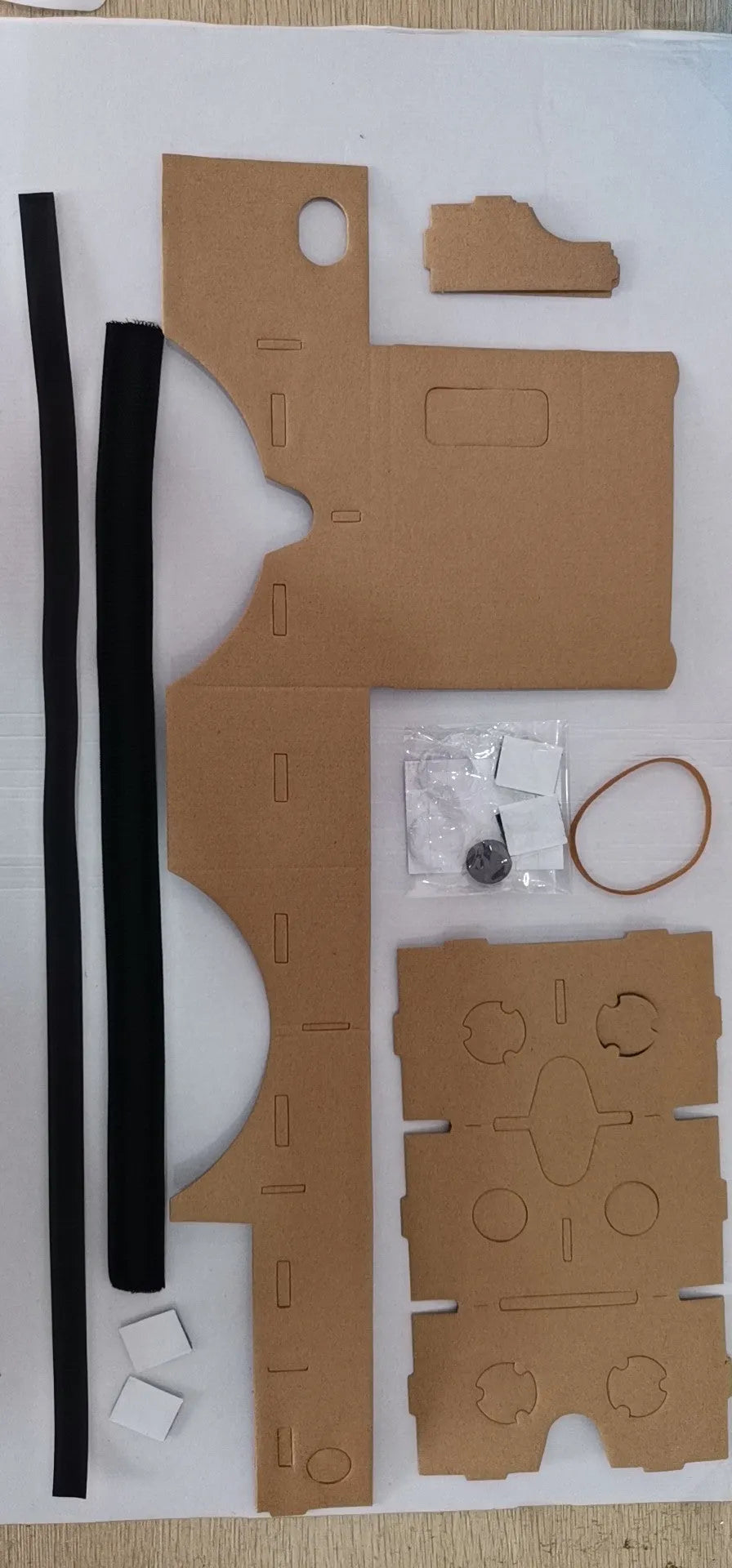 Flat-pack DIY VR cardboard glasses kit for 6-inch smartphones with 3D lenses, rubber band, and velcro strap.