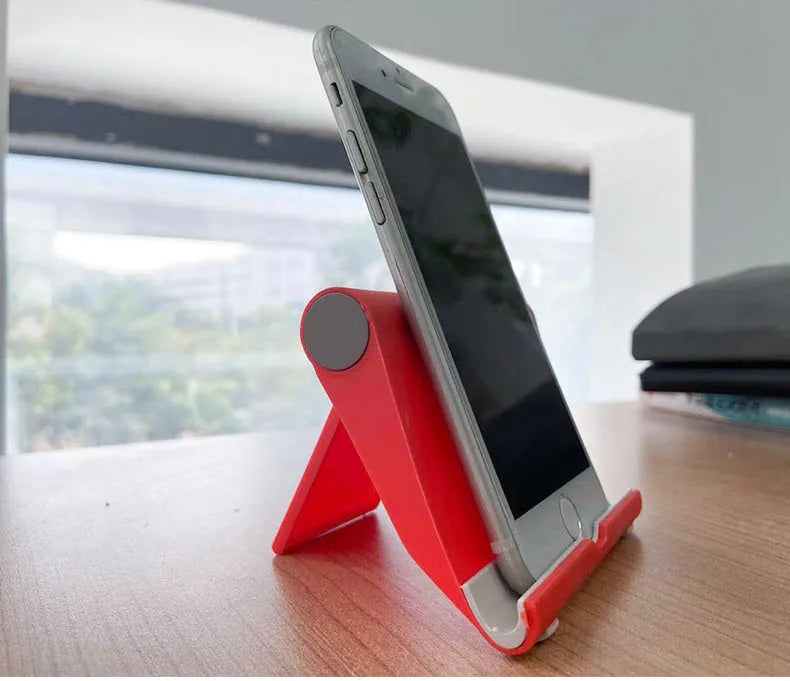 Black PE folding mobile phone stand with soft rubber grip in open position holding a smartphone
