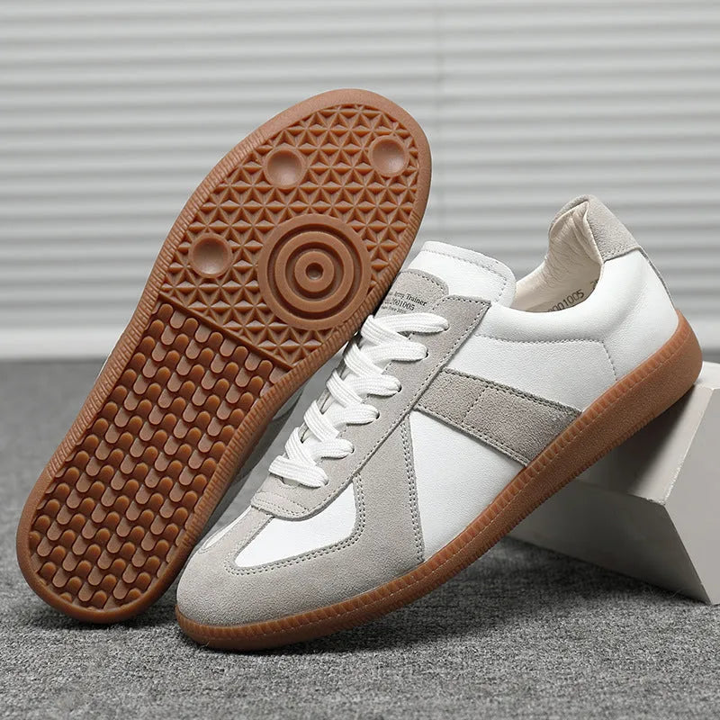White Japanese retro low-top sneakers with round toe and lace-up front on a rubber sole.