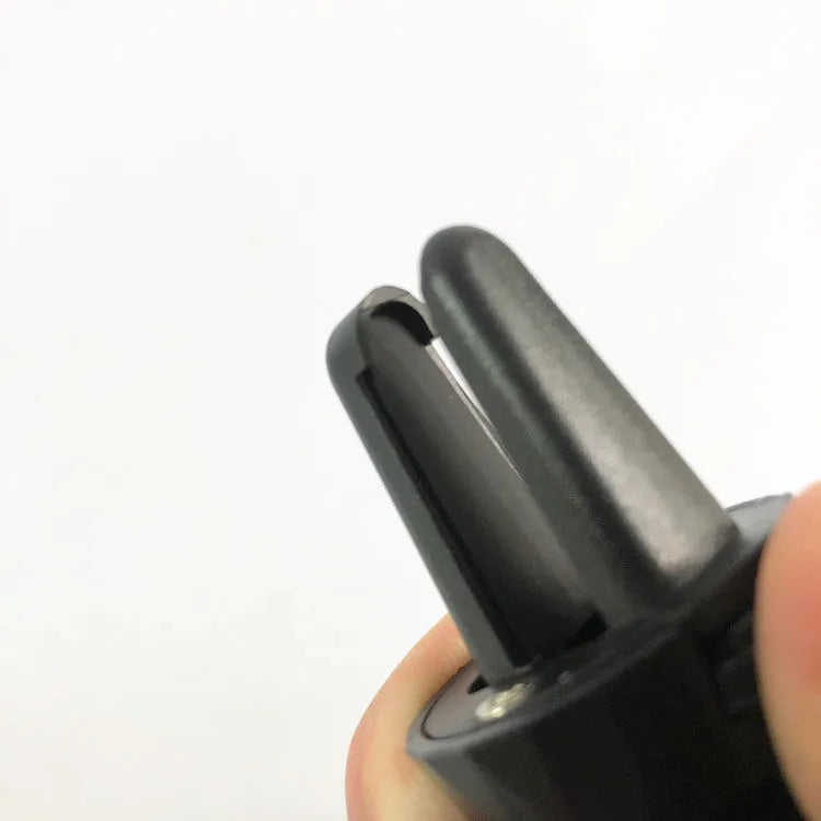 Black car phone holder attached to vehicle air vent holding smartphone