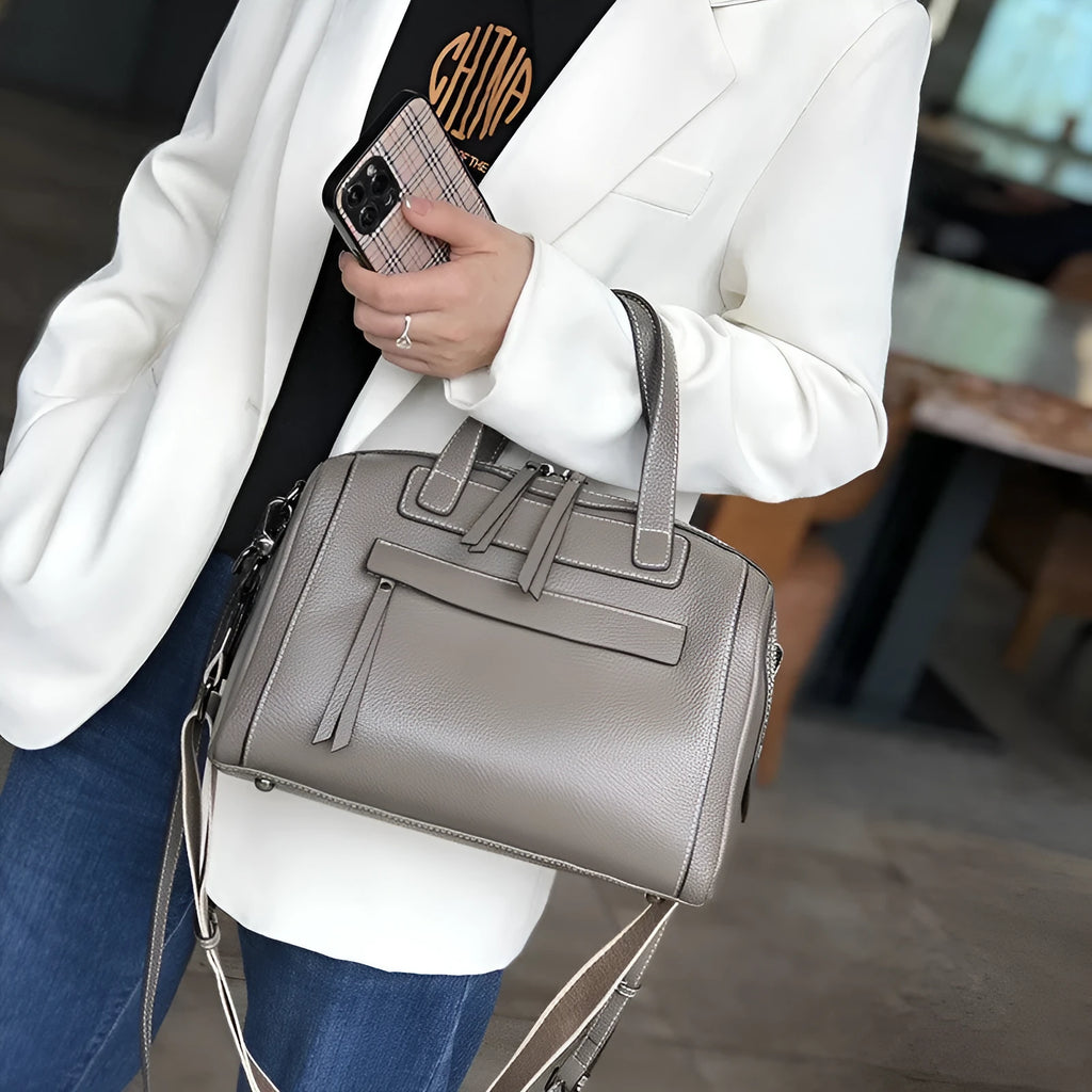 Brown genuine leather messenger bag with a textured lychee pattern, showing front flap and adjustable shoulder strap.