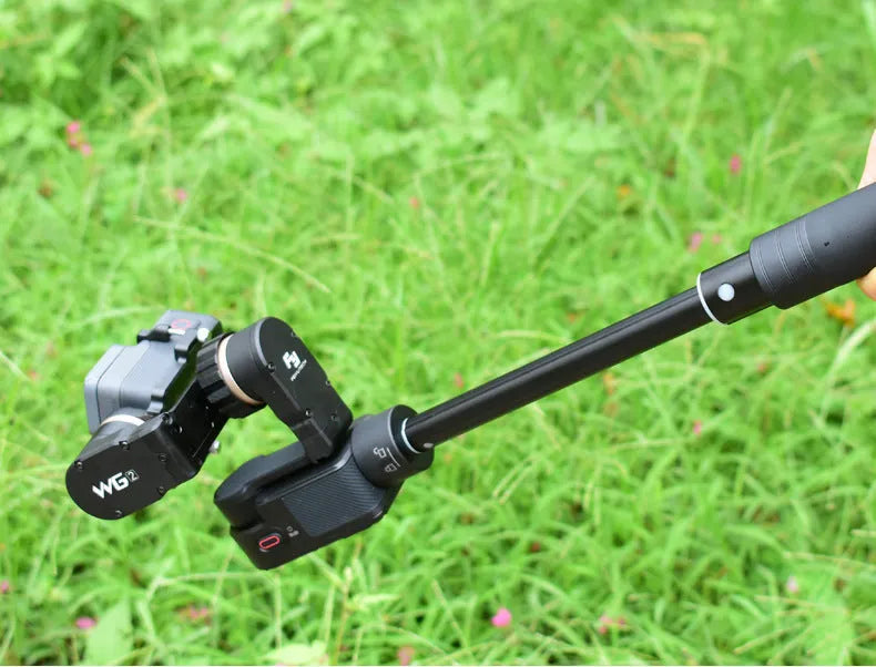 Black retractable selfie stick with phone bracket and anti-shake clip extended for use.
