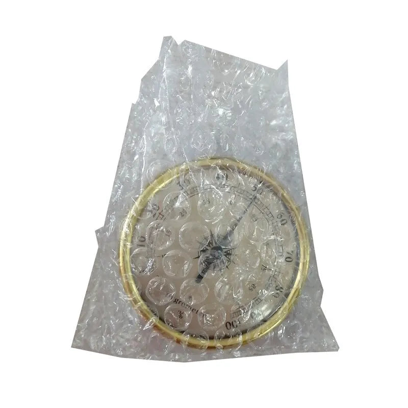 Analog thermometer and hygrometer with silver aluminum outer ring and dial on a white background
