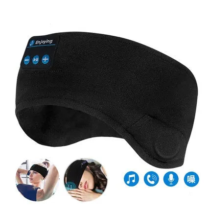 Black Bluetooth sleep eye mask with small integrated wireless earphones, shown in a relaxed position on a pillow.