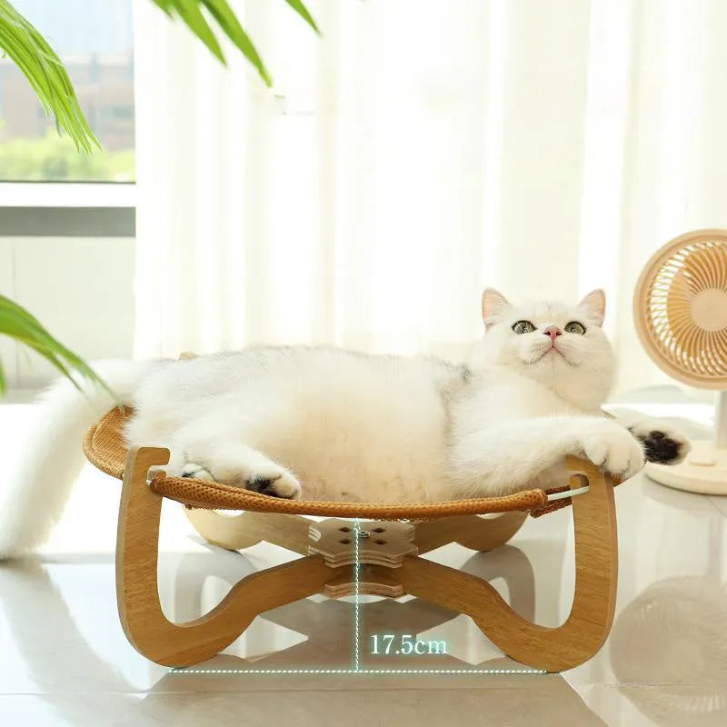 Natural brown woven rattan pet hammock with raised sides on a wooden floor.