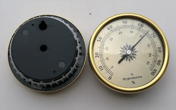 Analog thermometer and hygrometer with silver aluminum outer ring and dial on a white background