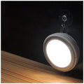 Wireless round motion sensor LED light with white plastic housing, shown mounted inside a wardrobe.