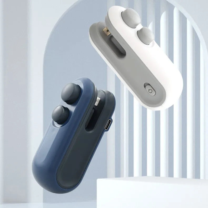 White and blue handheld USB heat sealer with cutter blade on a kitchen counter.