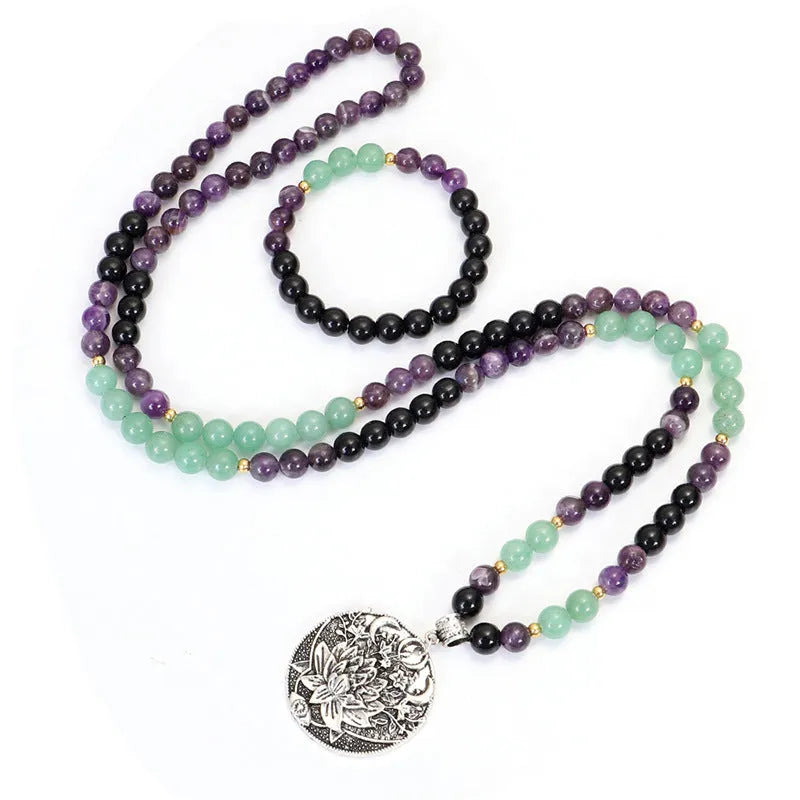 Long yoga necklace with lotus pendant and stone beads alongside matching bracelet