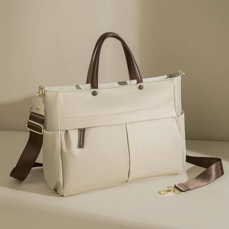 Women's Oxford cloth briefcase with shoulder strap showing open pocket organisation and contrast stitching details