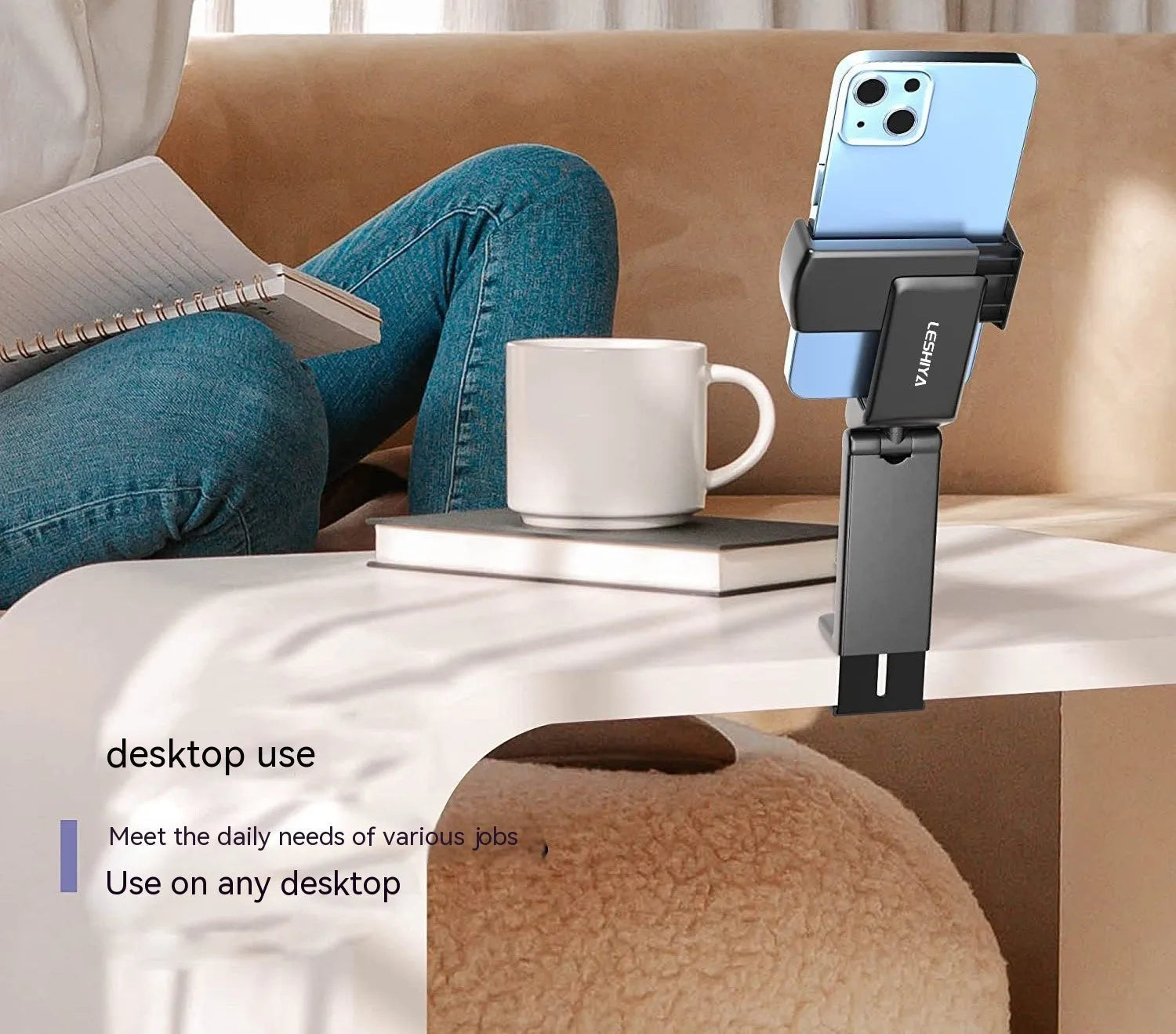 Black foldable rotating phone holder holding a mobile phone on a desk.