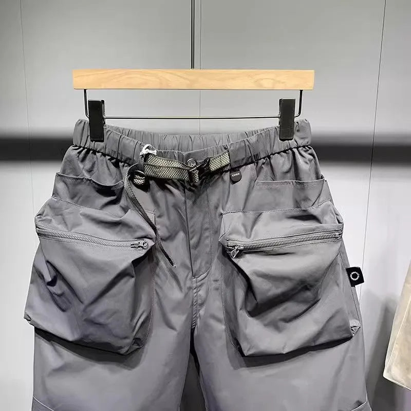 Men's loose fit black work shorts with pockets, shown on a model