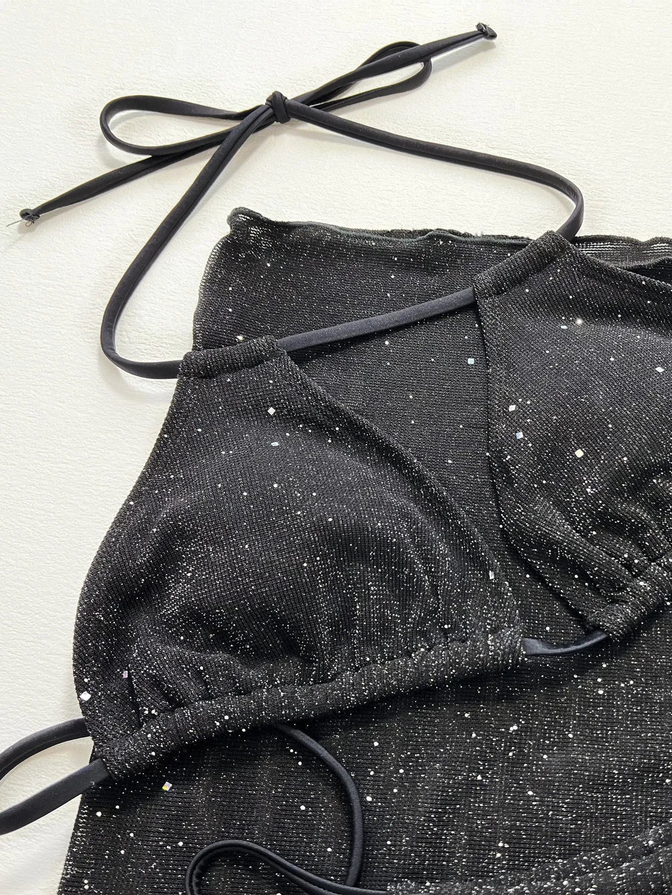 Black three-piece bikini swimsuit set with separate top and shorts on mannequin