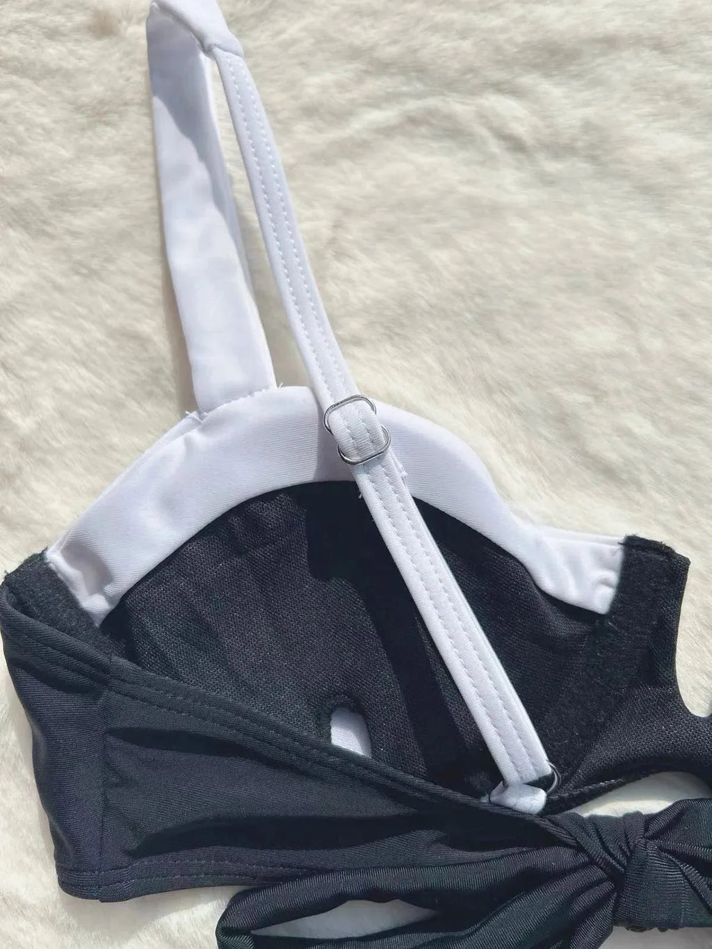 Black low waist women's bikini swimsuit with stitching split detail and briefs style.