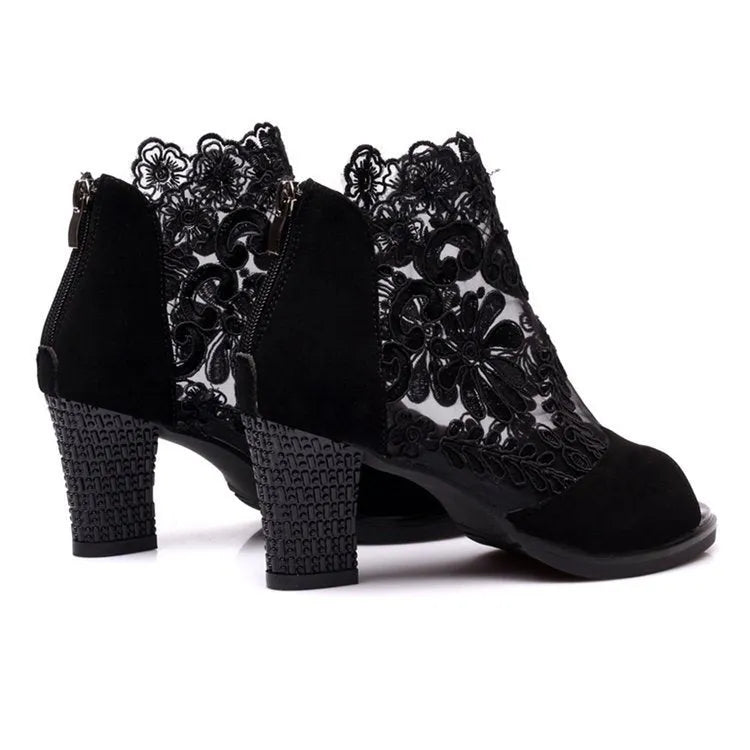 Women's black gladiator sandals with square heels and flower lace upper showing zip closure detail