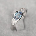 Geometric ellipse-shaped women's ring with inlaid zircon stones in a white gold finish.