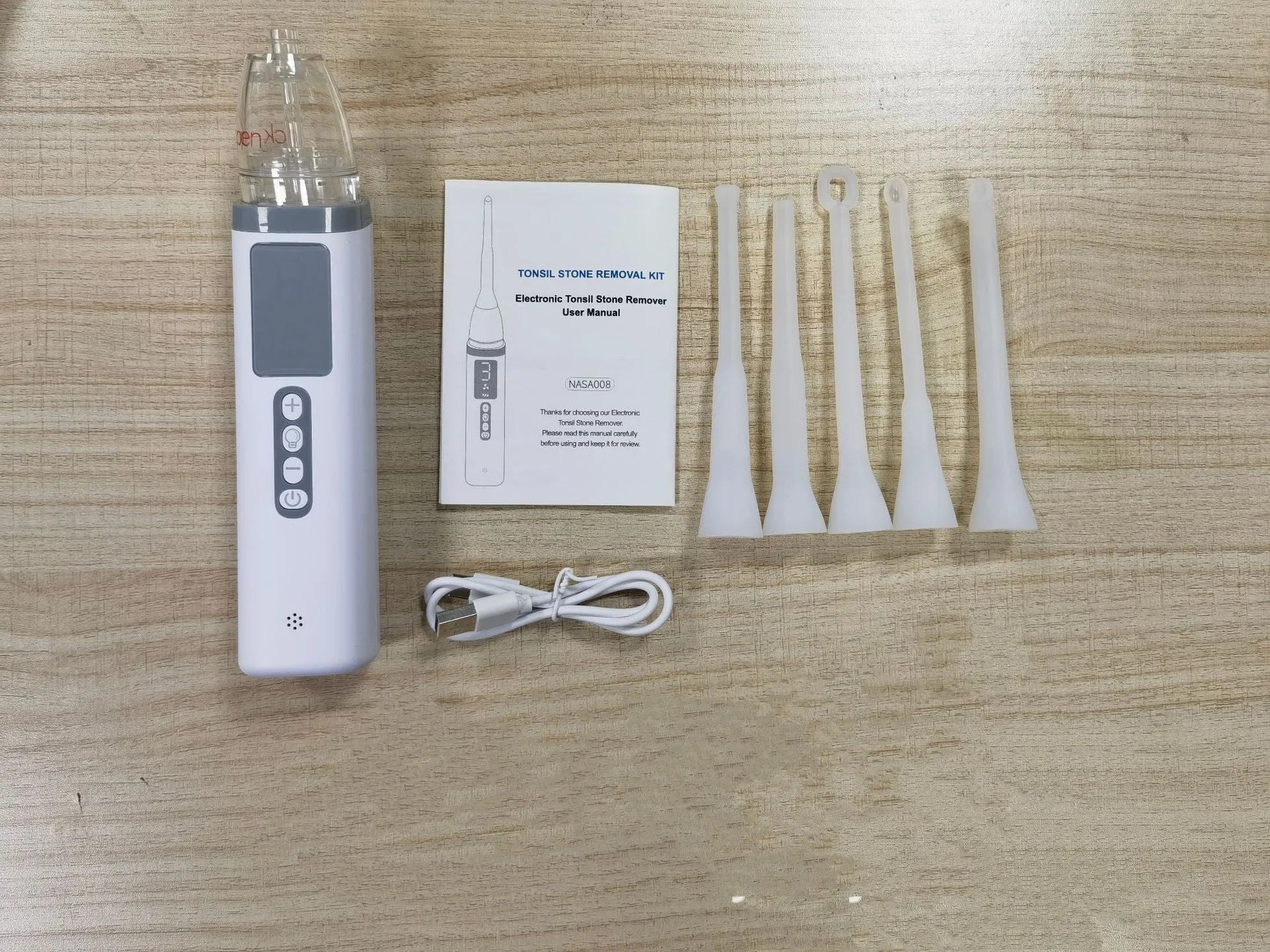 Milky white tonsil stone remover oral cleaning tool with built-in light on a white background.