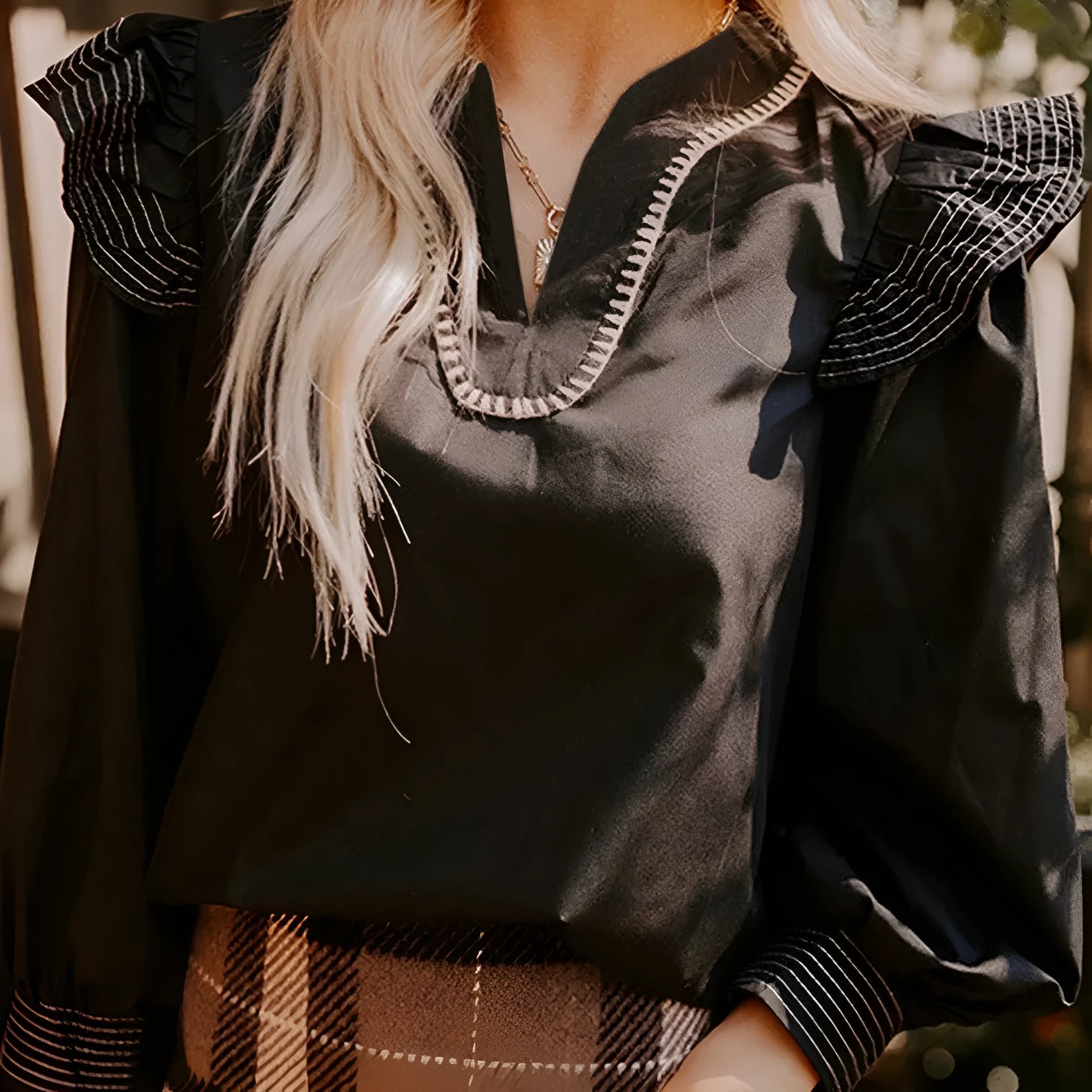 Black women's V-neck long sleeve blouse with ruffle detail and contrast stitching