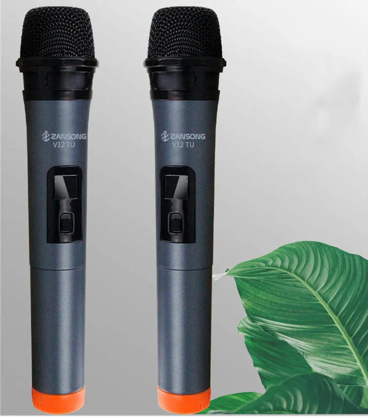 Black ZANSONG V12 dynamic wireless microphone with USB receiver and cables on a table.