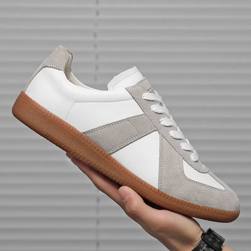 White Japanese retro low-top sneakers with round toe and lace-up front on a rubber sole.