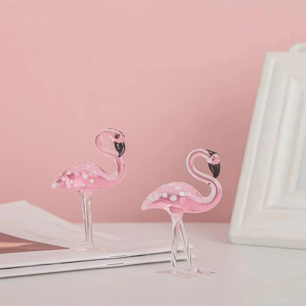Clear crystal flamingo decorative sculpture with pink dots on a table.