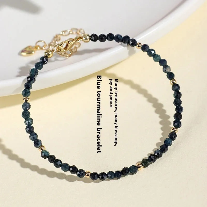 Blue tourmaline bracelet with 3mm cut beads and spacer design on white background