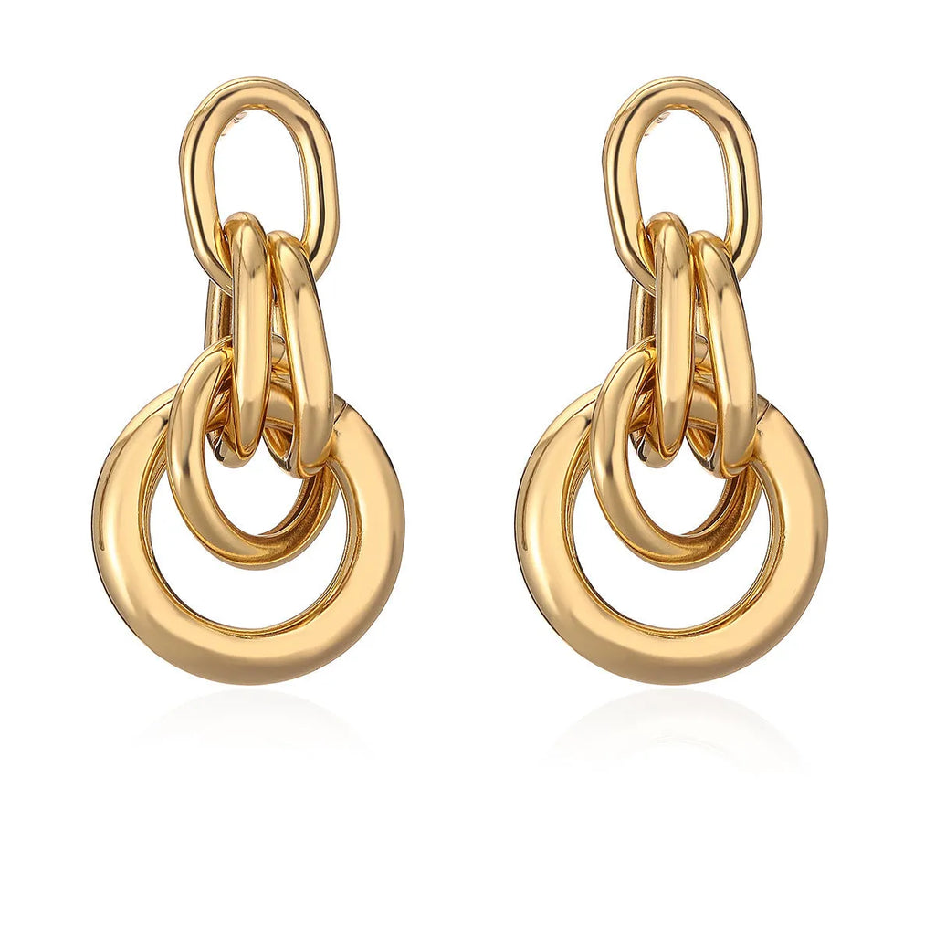 Geometric gold-coloured copper earrings with irregular design elements and high-profile construction